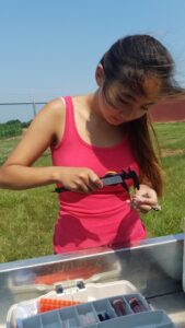 Student measuring tarsus of bird