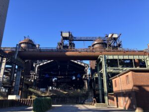 large pipe passes over an old industrial building, now climbing gym.