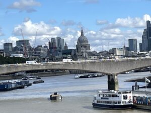 Thames River with boats in foreground, Waterloo Bridge in middle ground, skyline with St Paul's in background