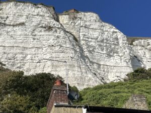 Chalk cliffs with blue sky above and houses below