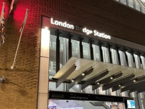 London Bridge Station at night with station sign lit, letter B R I burnt out in "bridge"