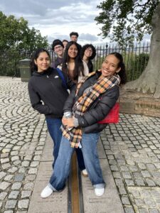 Students lined up, leaning in various directions, while standing on the Prime Meridian, longitude O.