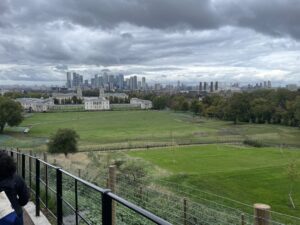 London skyline in distance with Royal Naval College buildings and large grass lawns in foreground