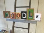 Stylized art blocks comprise the word "Moodle"